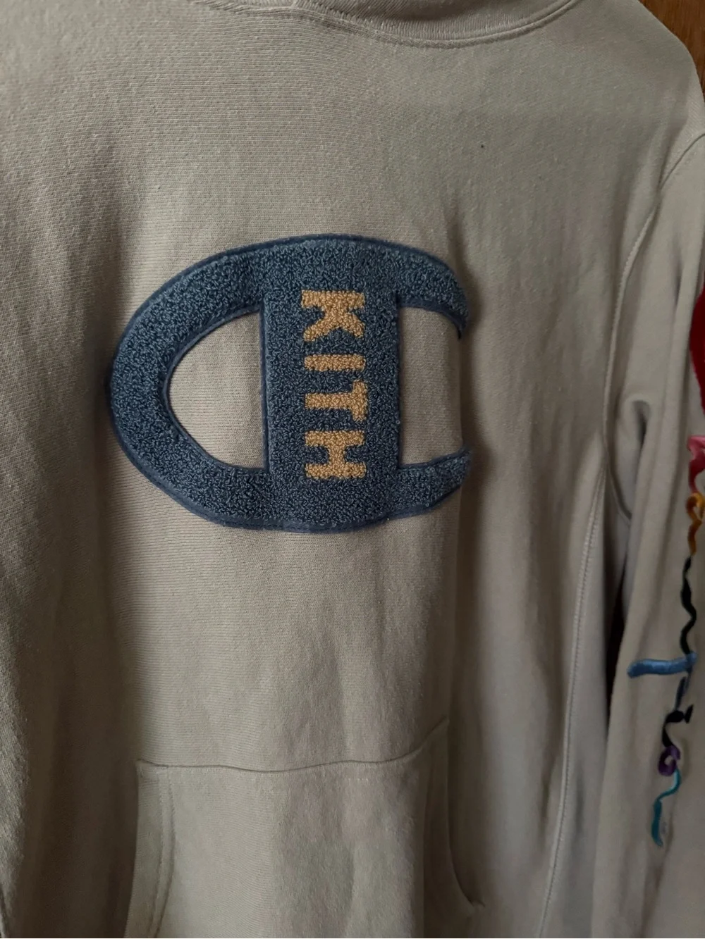 Kith and Champion Collab Beige Hoodie with Multicolor Sleeve Logo